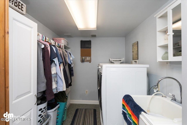 clothes washing area featuring laundry area, washer and dryer, visible vents, and baseboards