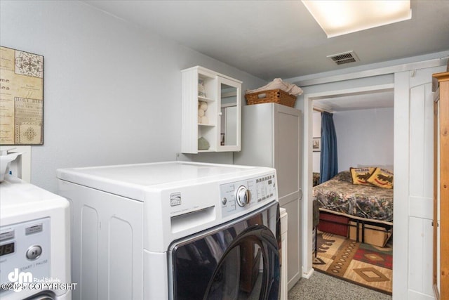 laundry area with laundry area, washer and dryer, and visible vents