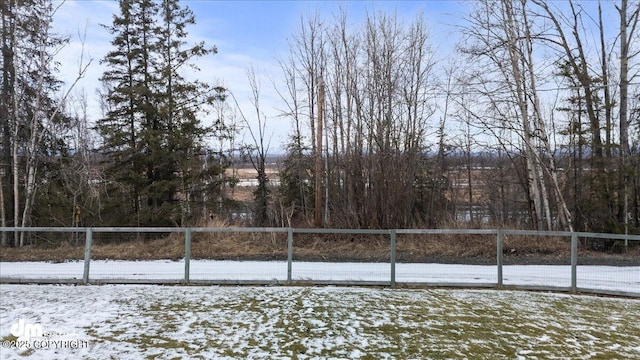 yard covered in snow featuring a fenced front yard