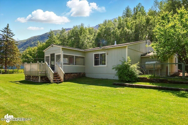 10833 E Twin Peaks Ct, Palmer, AK 99645 - back of property with a mountain view, a sunroom, and a yard