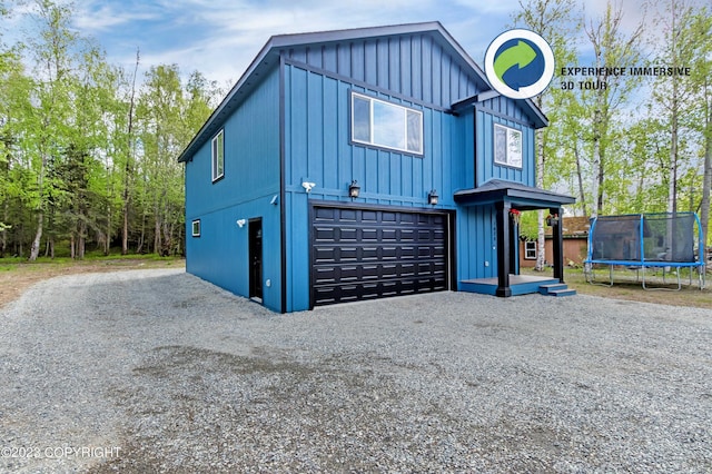 exterior space featuring a trampoline, an attached garage, and board and batten siding