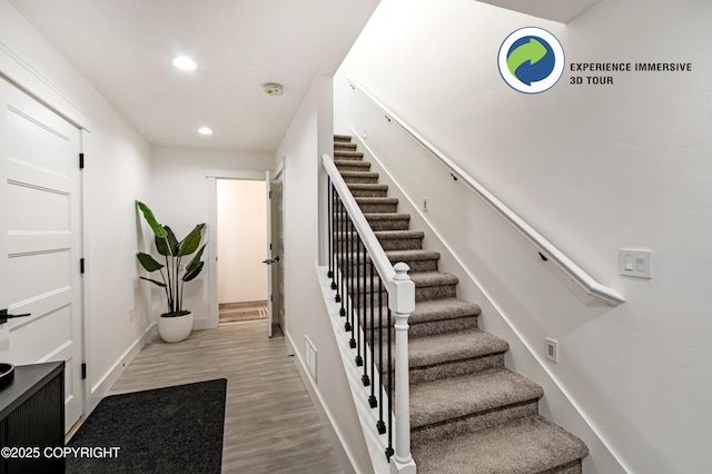 stairway featuring baseboards, wood finished floors, visible vents, and recessed lighting