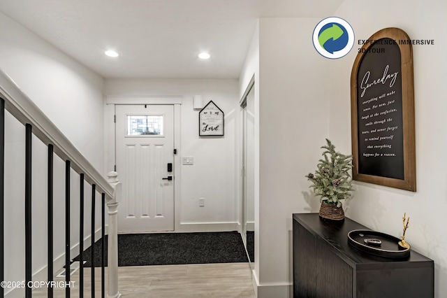 foyer entrance featuring stairs, baseboards, wood finished floors, and recessed lighting