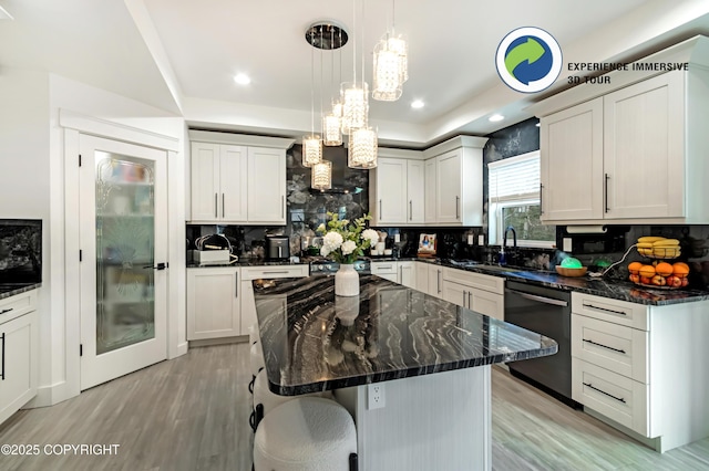 kitchen with recessed lighting, backsplash, dishwasher, light wood finished floors, and dark stone countertops