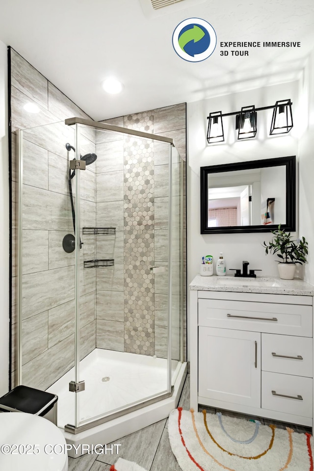 bathroom featuring a stall shower, vanity, and toilet