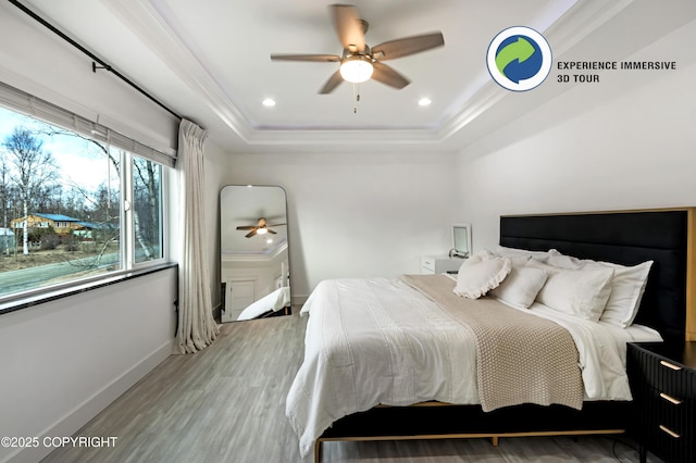 bedroom with crown molding, recessed lighting, a raised ceiling, wood finished floors, and baseboards