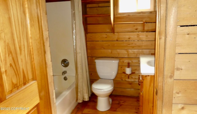 full bathroom with vanity, wood walls, toilet, and shower / bathtub combination with curtain