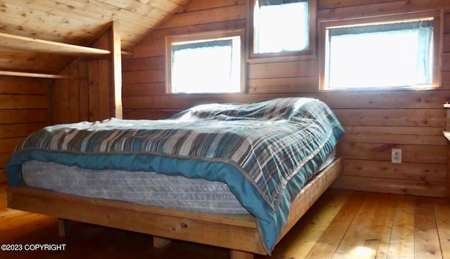 bedroom with wood-type flooring, lofted ceiling, wooden walls, and wood ceiling