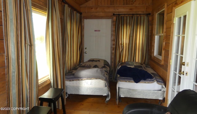 bedroom featuring wood walls and wood-type flooring