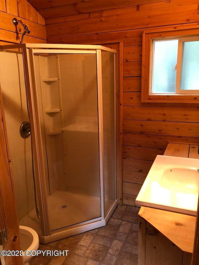 bathroom featuring an enclosed shower, vanity, vaulted ceiling, toilet, and wood walls