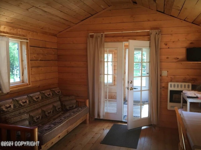 entryway with heating unit, wood walls, french doors, and hardwood / wood-style flooring