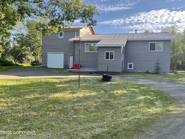 1832 Nerka Loop, Dillingham, AK 99576 - rear view of house featuring asphalt driveway, an attached garage, metal roof, and a lawn