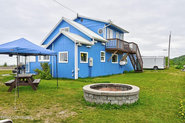 15264 Airport Ln, Ninilchik, AK 99639 - rear view of property featuring stairs, an outdoor fire pit, a deck, and a yard