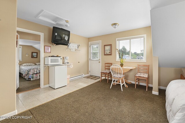 interior space with baseboard heating, lofted ceiling, and light tile patterned floors