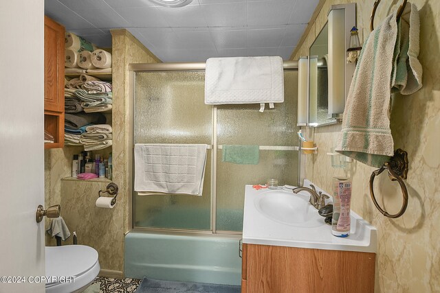 full bathroom with vanity, toilet, and combined bath / shower with glass door