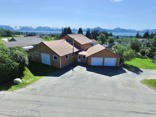 view of front of house with a front lawn, a mountain view, and a garage