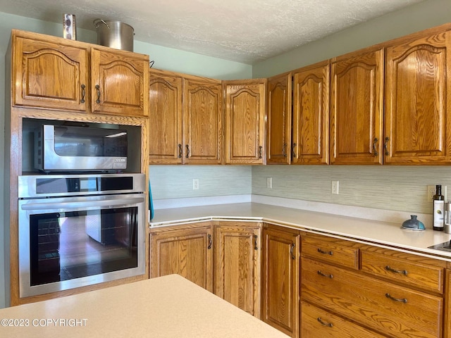 kitchen with a textured ceiling and appliances with stainless steel finishes