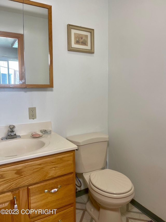 bathroom with tile floors, toilet, and vanity