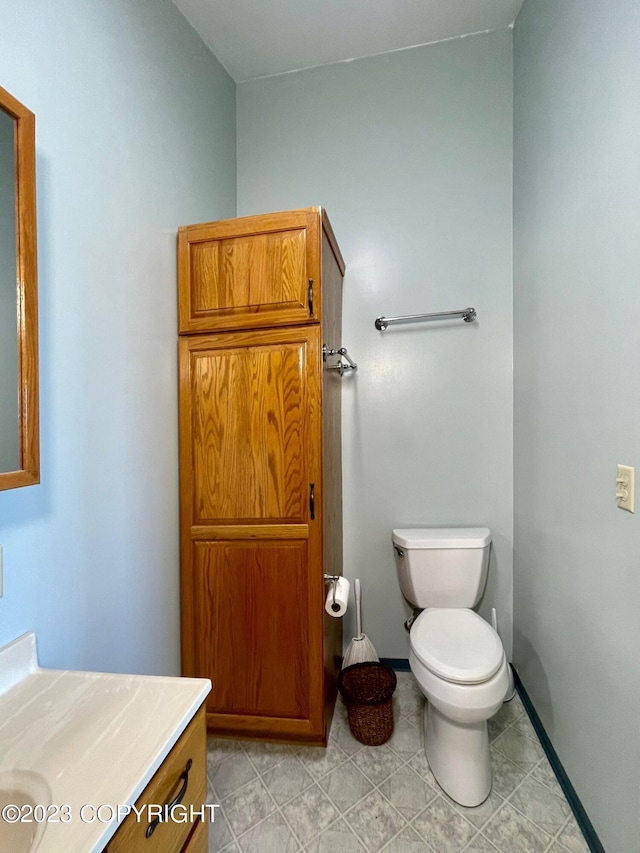 bathroom with toilet, tile flooring, and vanity