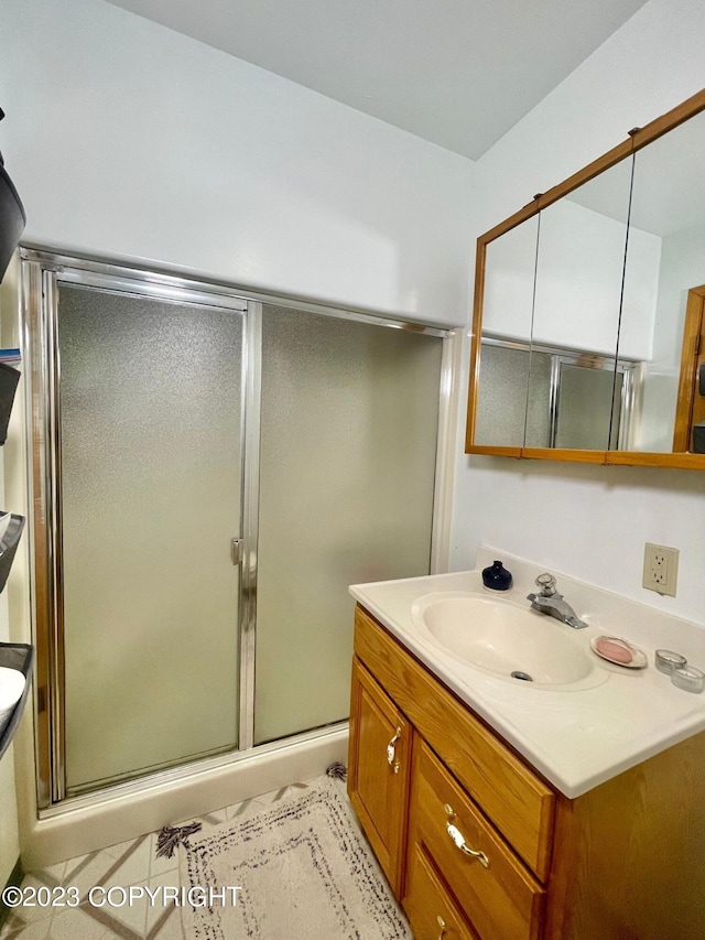 bathroom with tile flooring, an enclosed shower, and oversized vanity