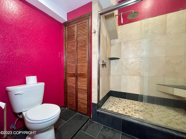 bathroom featuring toilet, tile floors, and a shower with door