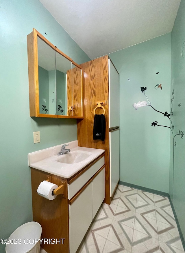 bathroom with toilet, vanity with extensive cabinet space, and tile floors