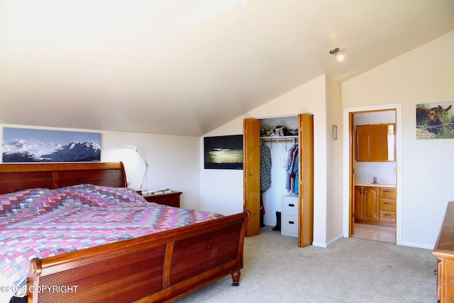 bedroom featuring light carpet, connected bathroom, vaulted ceiling, and a closet