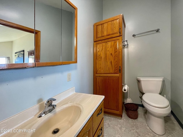 bathroom with toilet, tile flooring, and vanity