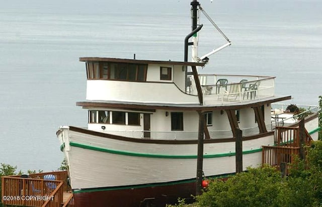 rear view of property featuring a water view and a balcony