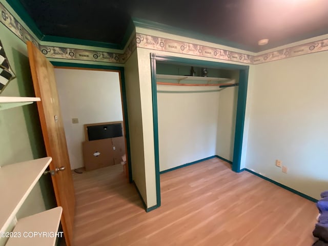 unfurnished bedroom with light wood-type flooring and a closet