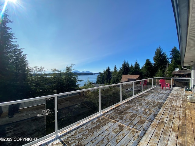 wooden deck featuring a water and mountain view