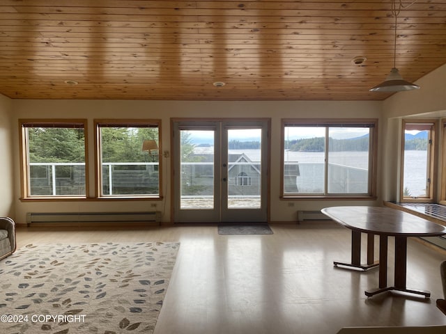unfurnished sunroom featuring lofted ceiling, baseboard heating, and wood ceiling