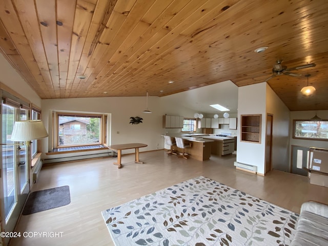 living room with lofted ceiling, light wood-type flooring, wood ceiling, plenty of natural light, and a baseboard radiator