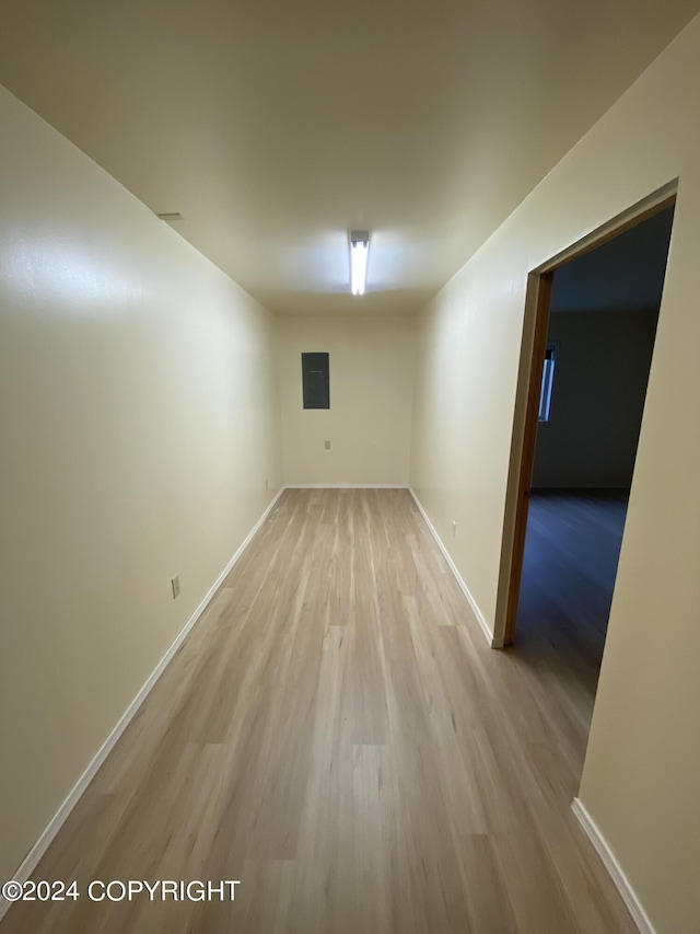 empty room featuring electric panel and light wood-type flooring