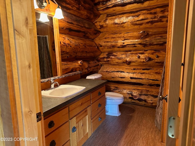 344 Eagle Bluff Dr, Haines, AK 99827 - bathroom featuring toilet, wood finished floors, log walls, and vanity