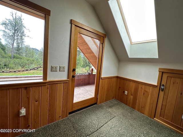344 Eagle Bluff Dr, Haines, AK 99827 - additional living space with carpet, wood walls, wainscoting, and vaulted ceiling with skylight