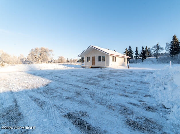 view of snow covered rear of property