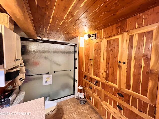 bathroom featuring toilet, tile patterned floors, wood ceiling, and a shower with shower door