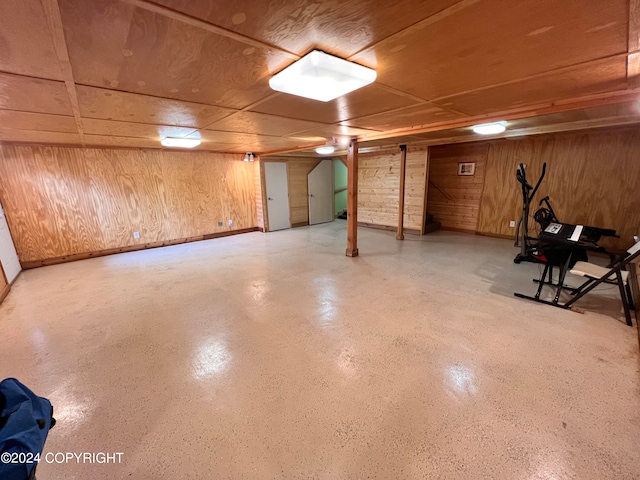 basement featuring wood walls