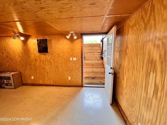 unfurnished room featuring wood ceiling and wooden walls