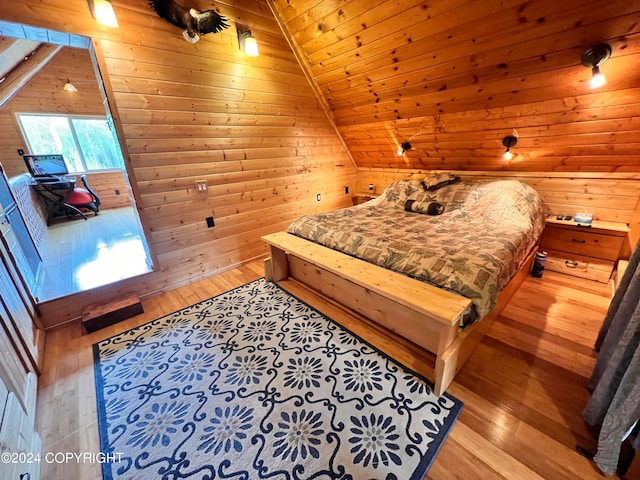 bedroom with light hardwood / wood-style floors, wooden ceiling, and wood walls