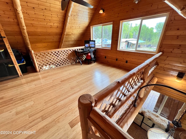 interior space with lofted ceiling, hardwood / wood-style flooring, ceiling fan, wooden ceiling, and wood walls