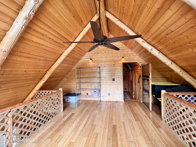 additional living space featuring wood walls, wood-type flooring, lofted ceiling with beams, and wooden ceiling