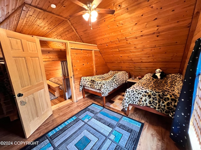 bedroom with wood ceiling, wooden walls, vaulted ceiling, and hardwood / wood-style flooring