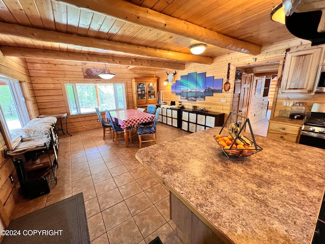 dining space featuring beamed ceiling, a healthy amount of sunlight, wooden ceiling, and wooden walls