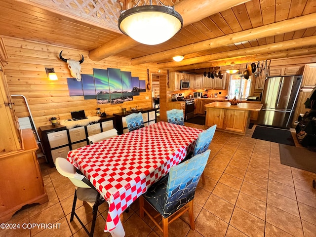 dining room featuring beamed ceiling, wooden walls, light tile patterned floors, and wooden ceiling