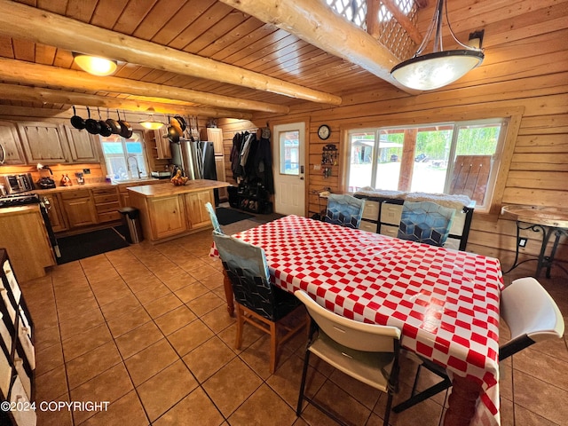 dining room with beam ceiling, wood ceiling, wooden walls, and a wealth of natural light