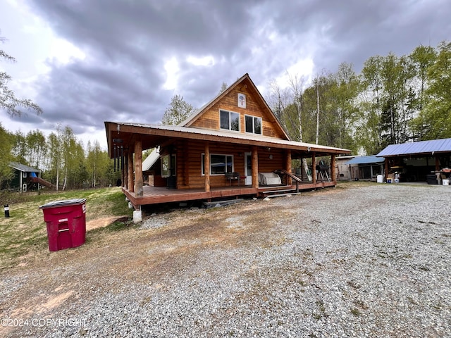 log cabin with a carport and a porch