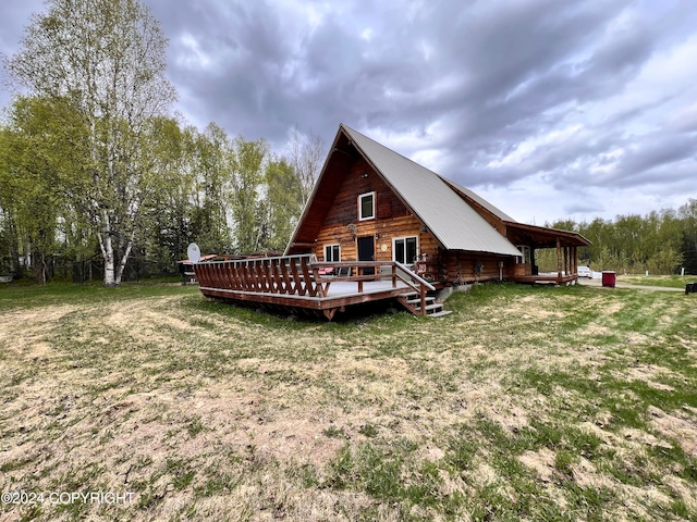 rear view of property featuring a wooden deck and a yard