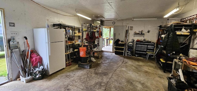 interior space with white refrigerator and a workshop area